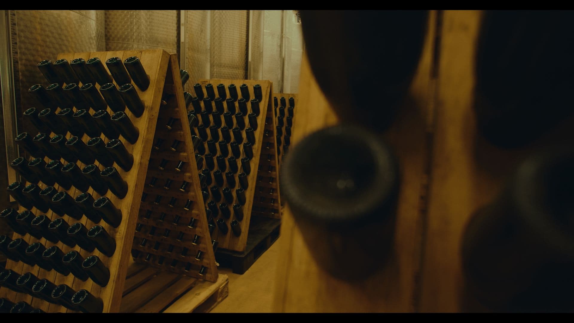 Flasker lagrer på skrå træstativer hos Andersen Winery